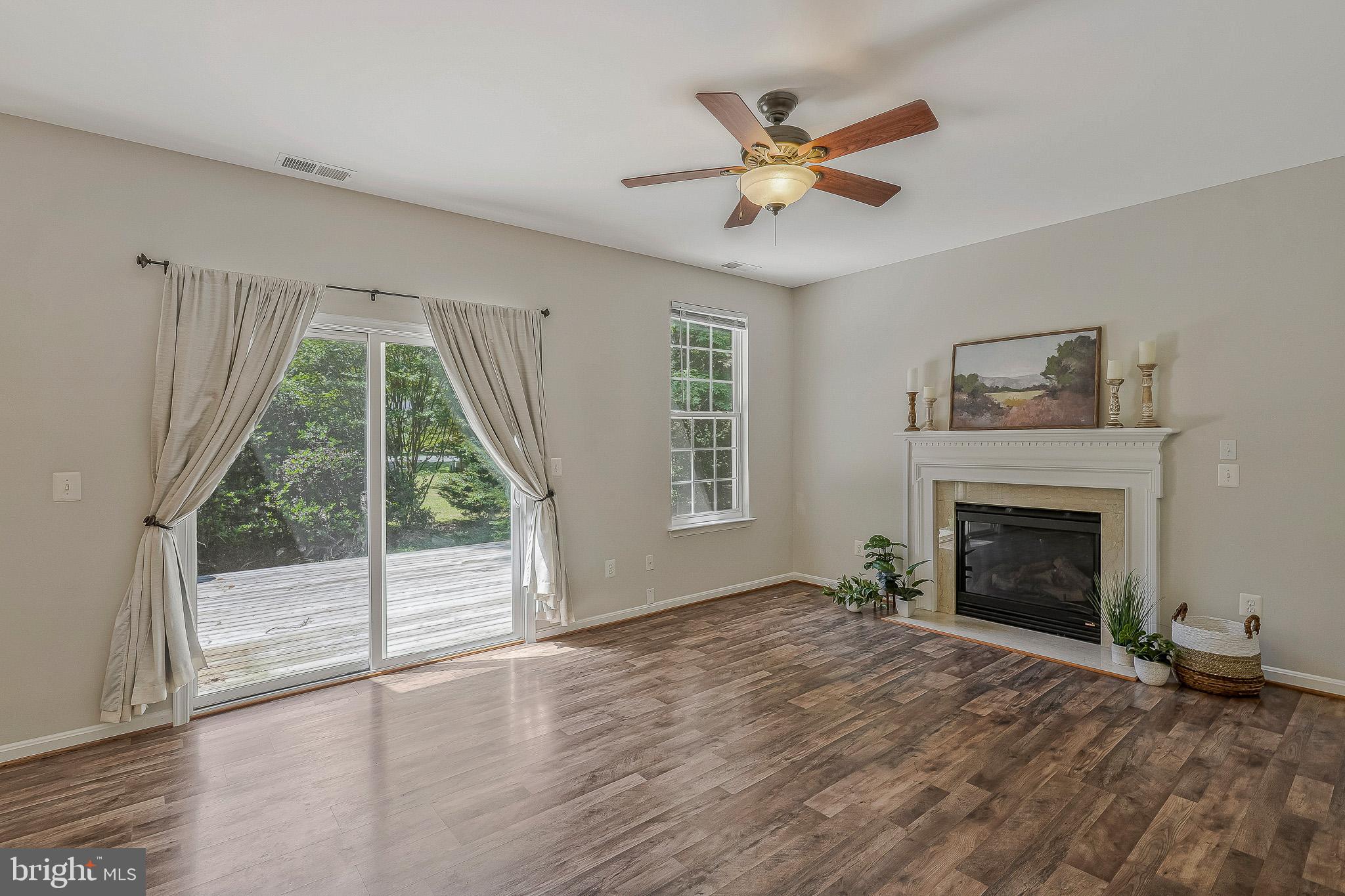 11587 Wollaston Circle Swan Point, MD 20645 - Photo 13 of 55 a view of an empty room with wooden floor fireplace and a window