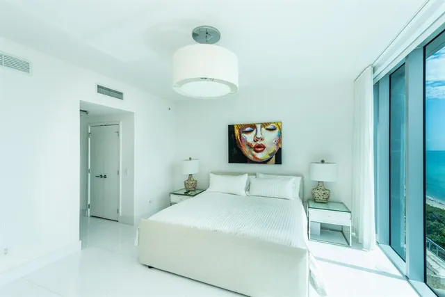 a bedroom with a bed and a painting on the wall