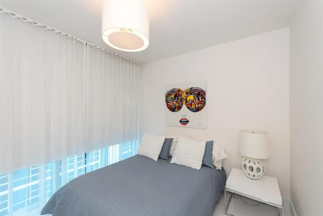 a bedroom with a bed and painting on the wall