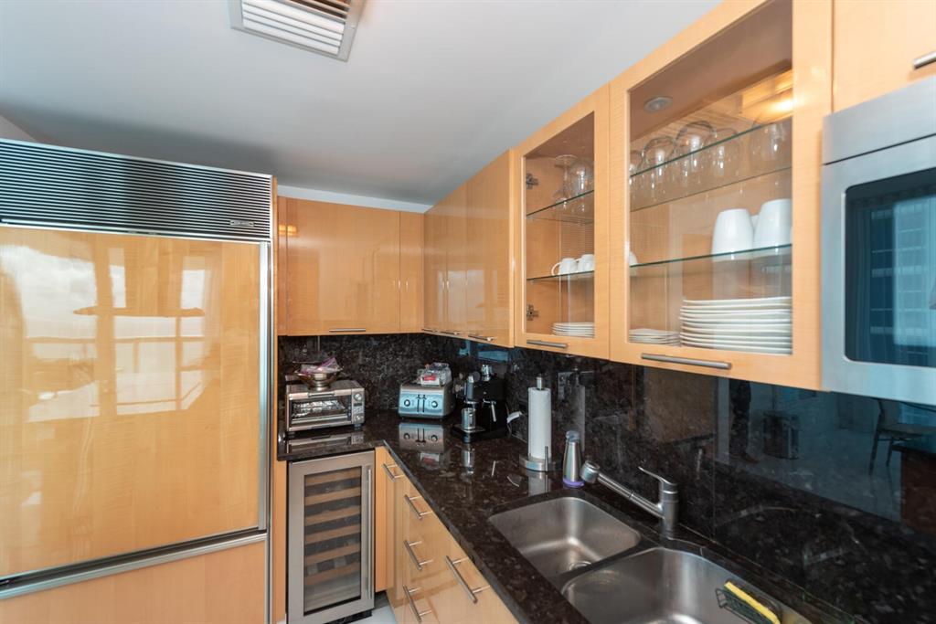 6899 Collins Avenue, Unit 908 Miami Beach, FL 33141 - Photo 9 of 19 a kitchen with granite countertop a sink and a window