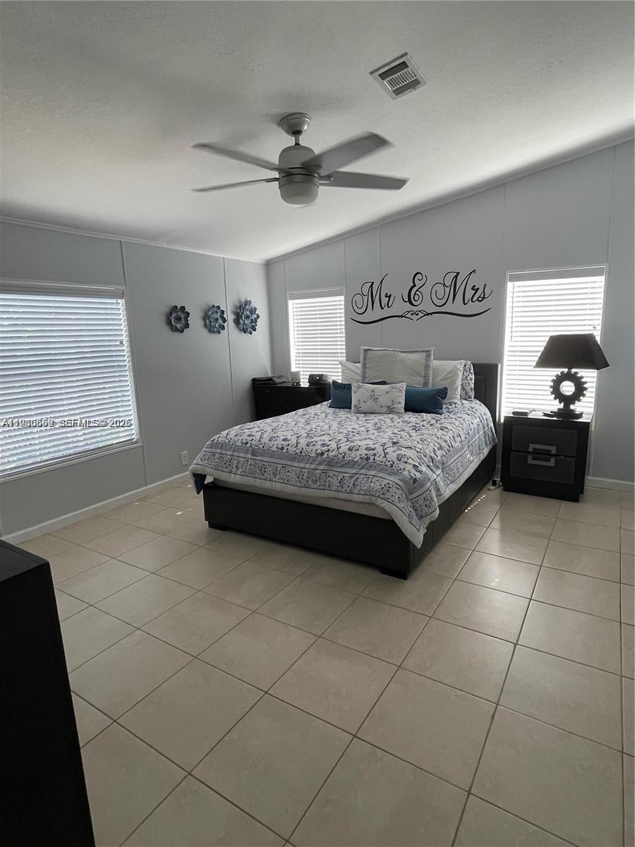 19800 Southwest 180th Avenue Miami, FL 33187 - Photo 4 of 9 a bedroom with a bed and a table in it