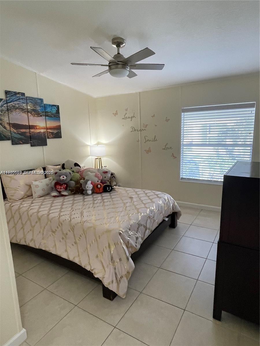19800 Southwest 180th Avenue Miami, FL 33187 - Photo 5 of 9 a bedroom with a bed and window