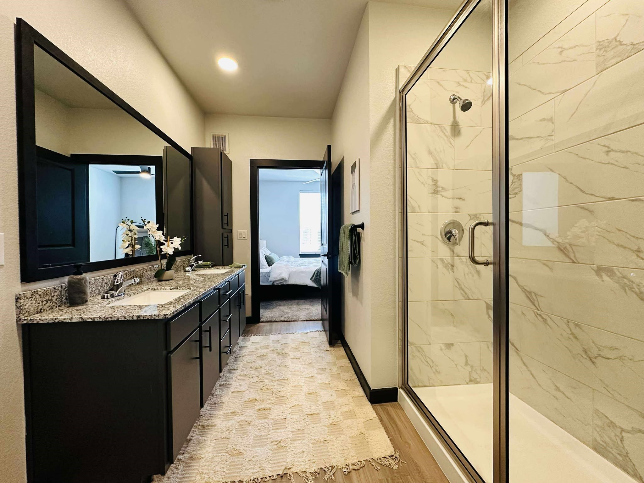 2603 North Fry Road, Unit B1 Katy, TX 77449 - Photo 12 of 13 a bathroom with a granite countertop sink a mirror and a shower