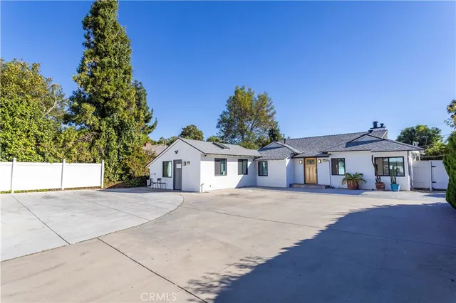a front view of a house with a garden and yard