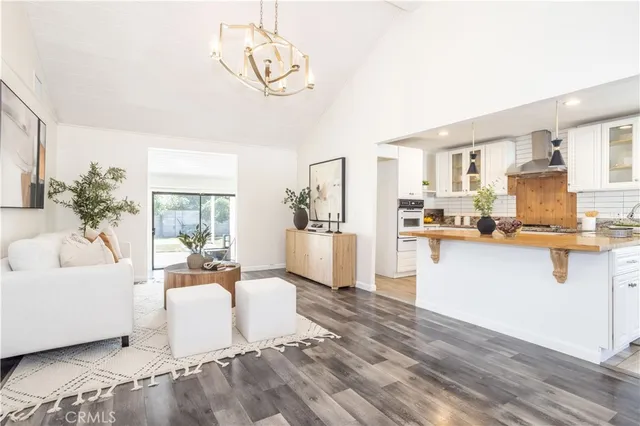 a living room with kitchen island furniture and a chandelier