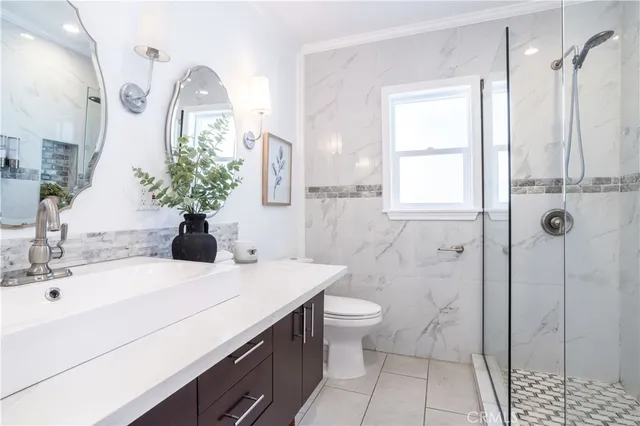 a bathroom with a sink a toilet and shower