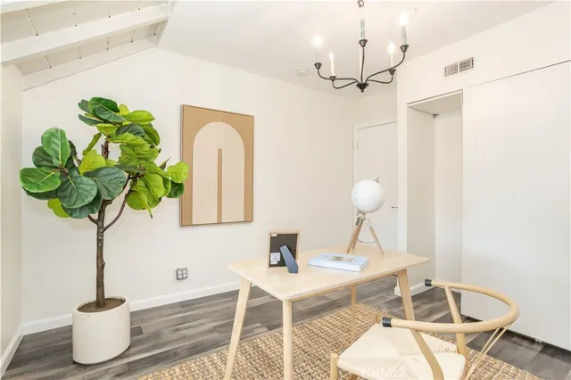 a vase of flowers sitting on a table with a chandelier