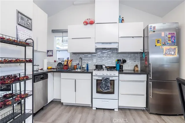 a kitchen with stainless steel appliances a stove a refrigerator and cabinets