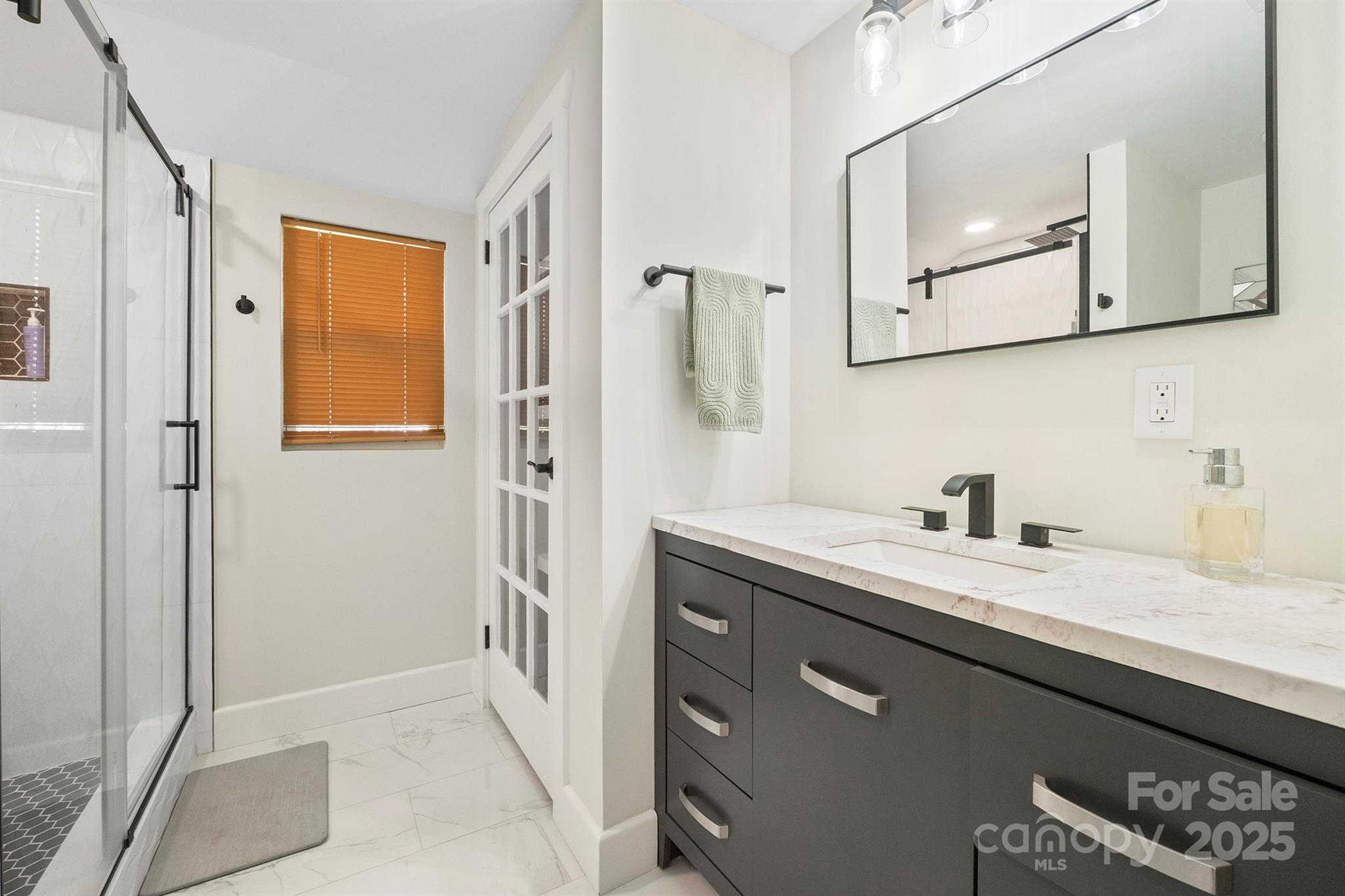 600 3rd Street Spencer, NC 28159 - Photo 15 of 27 a bathroom with a granite countertop sink a mirror and a shower