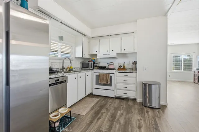 a kitchen with white cabinets and white appliances