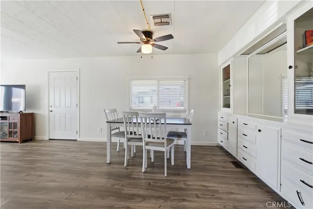 a dining room with furniture a chandelier and wooden floor