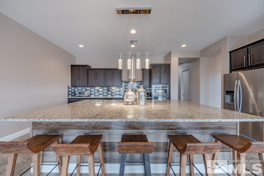 9875 Firefoot Lane Reno, NV 89521 - Photo 11 of 29 a kitchen with kitchen island granite countertop a counter space dining table and stainless steel appliances