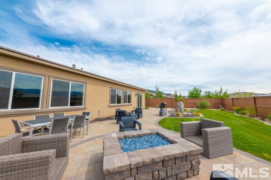 9875 Firefoot Lane Reno, NV 89521 - Photo 26 of 29 a view of a patio with couches dining table and chairs with wooden floor and fence