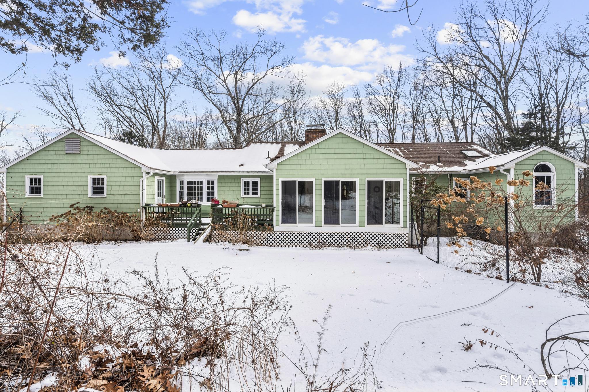 4 Twist Hill Road Newtown, CT 06470 - Photo 37 of 40 a patio with a table and chairs under an umbrella