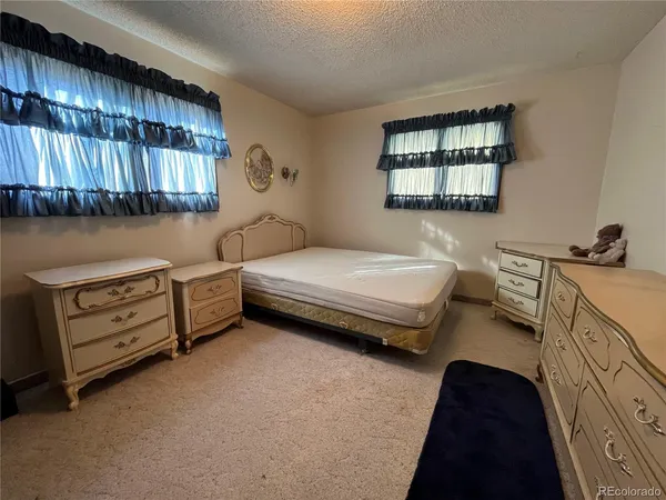 a bedroom with a bed dresser and a window