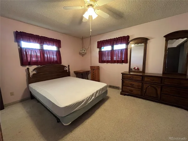a bedroom with a bed and a mirror on dresser