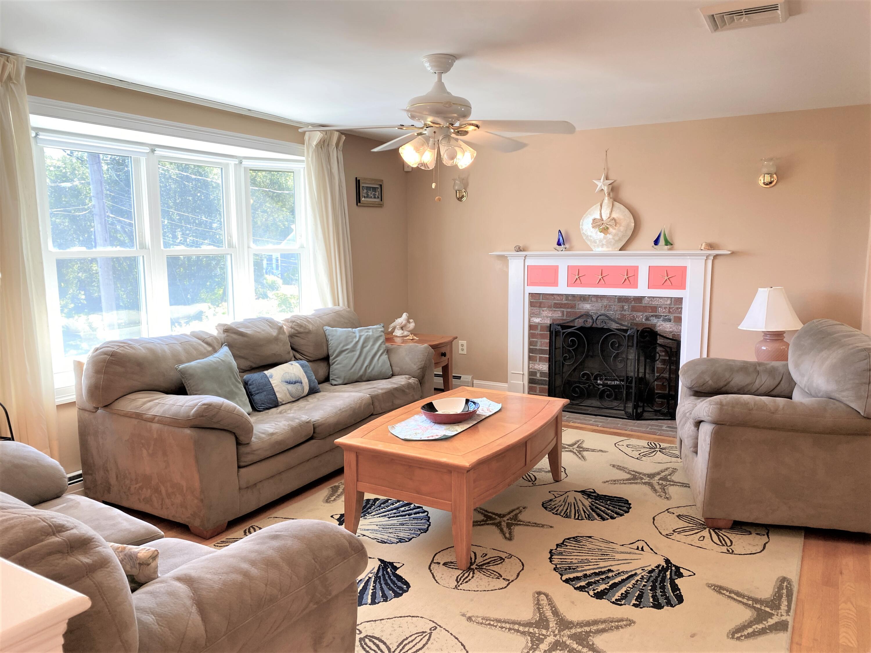 25 Ripple Cove Road Hyannis, MA 02601 - Photo 3 of 38 a living room with furniture a fireplace and a chandelier
