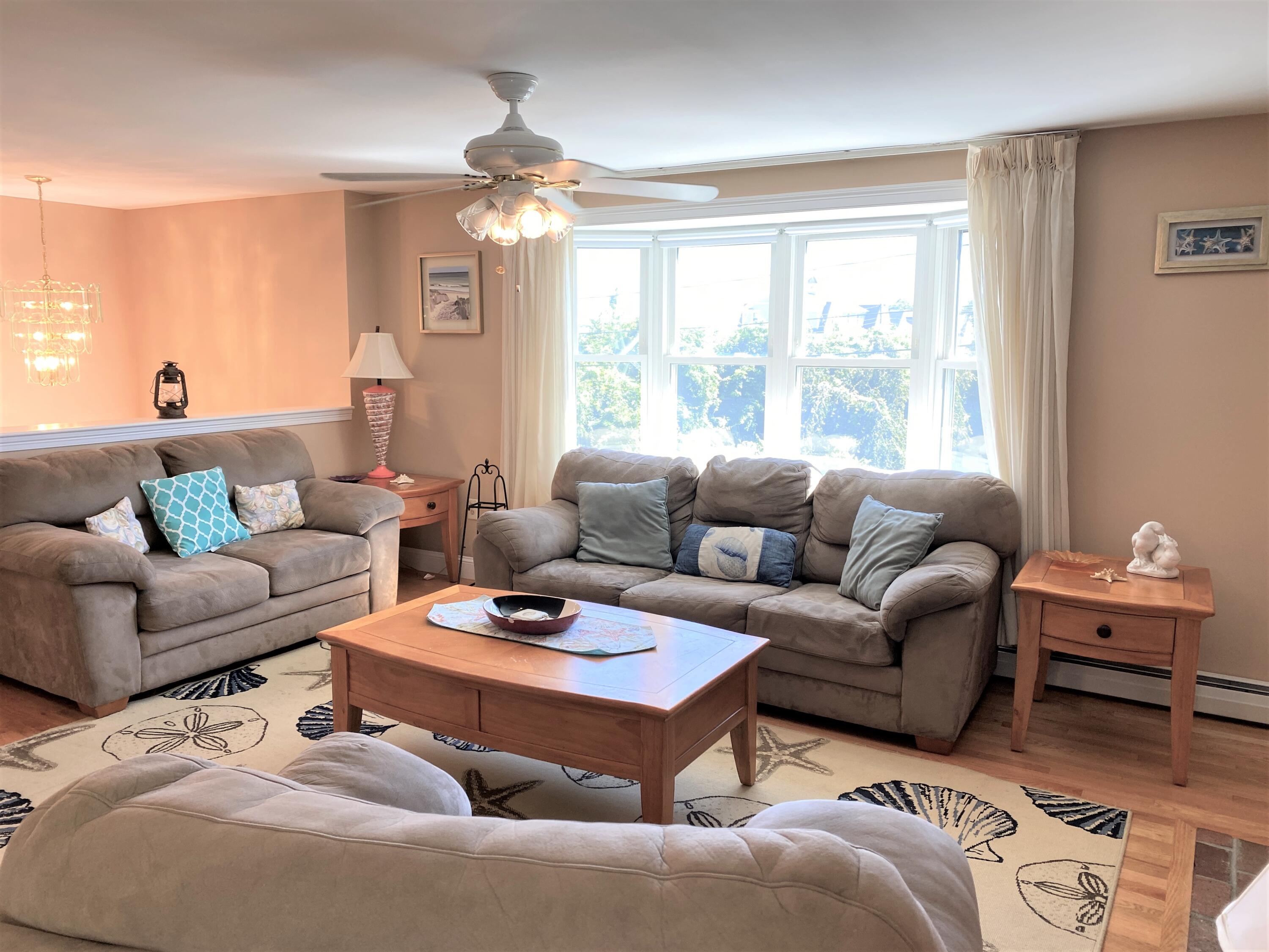 25 Ripple Cove Road Hyannis, MA 02601 - Photo 4 of 38 a living room with furniture a large window and a chandelier