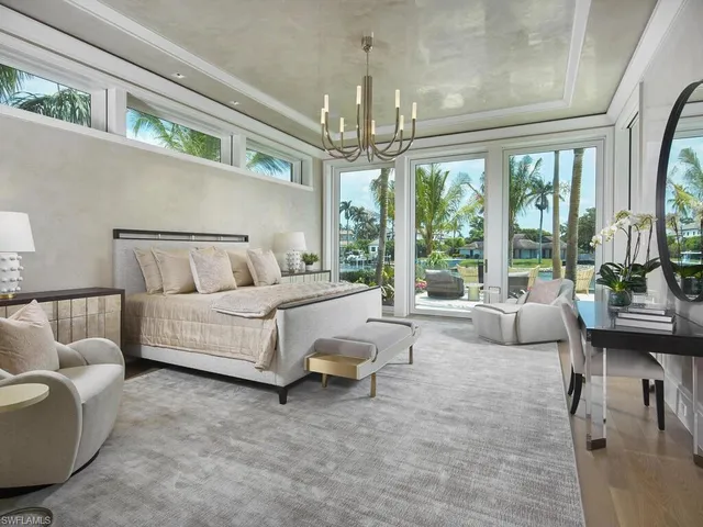 a bedroom with a bed and a large window with balcony view