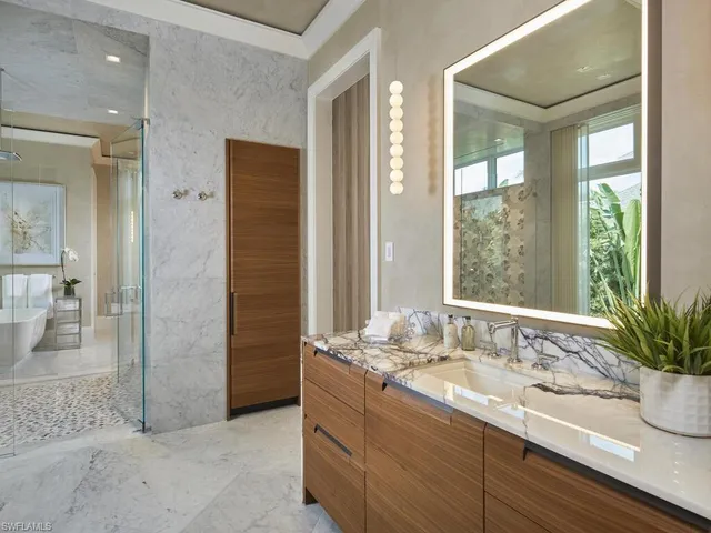 a bathroom with a granite countertop sink a large mirror and a shower