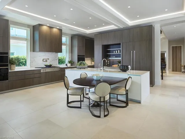 a dining hall with stainless steel appliances a dining table and chairs