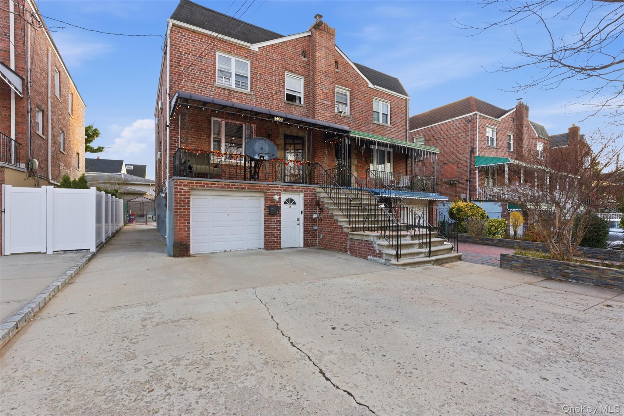 Traditional-style house featuring brick siding, driveway, and a garage