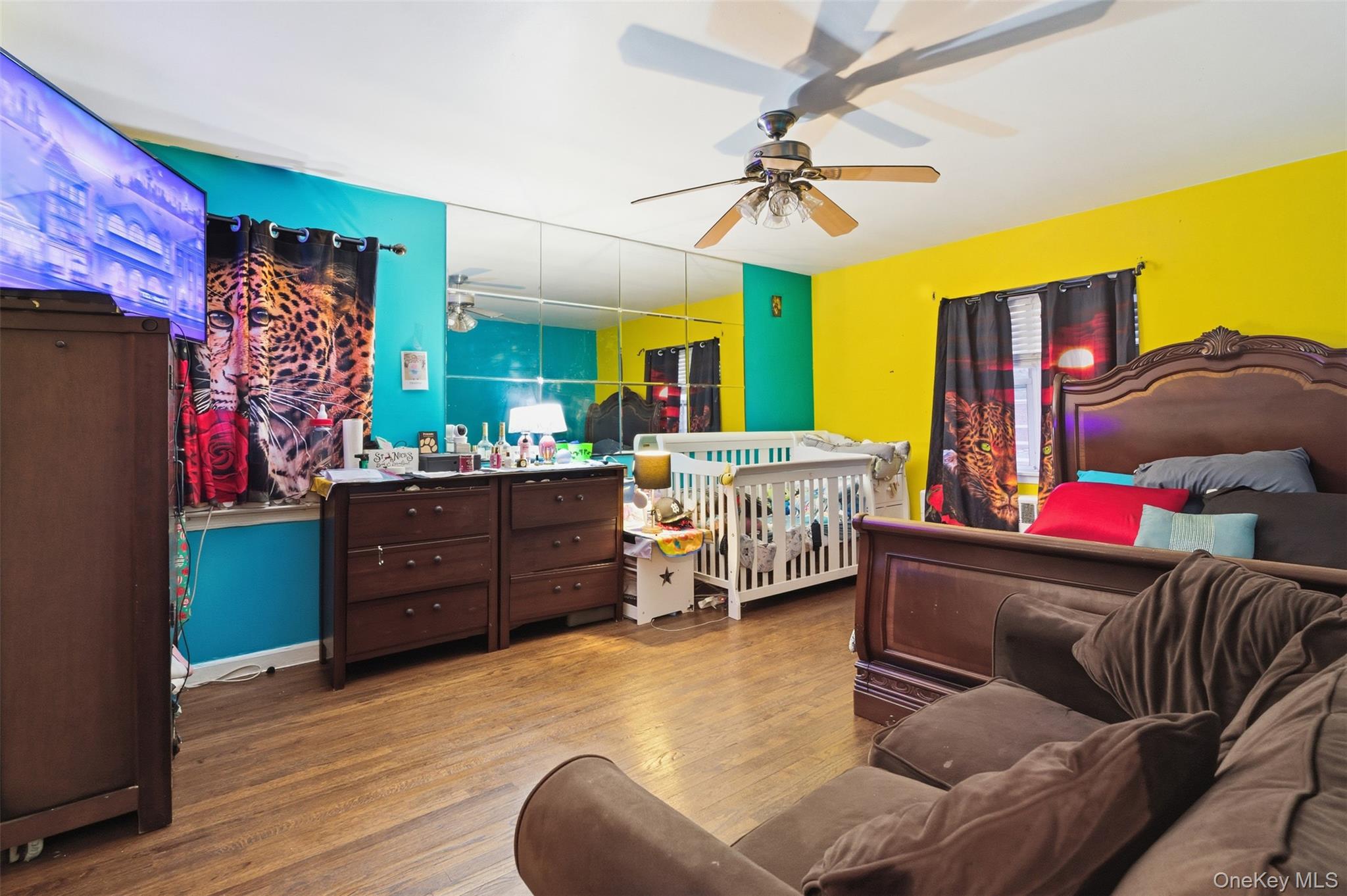 1408 Astor Avenue Bronx, NY 10469 - Photo 12 of 21 Master Bedroom with wood finished floors, a ceiling fan, and a crib