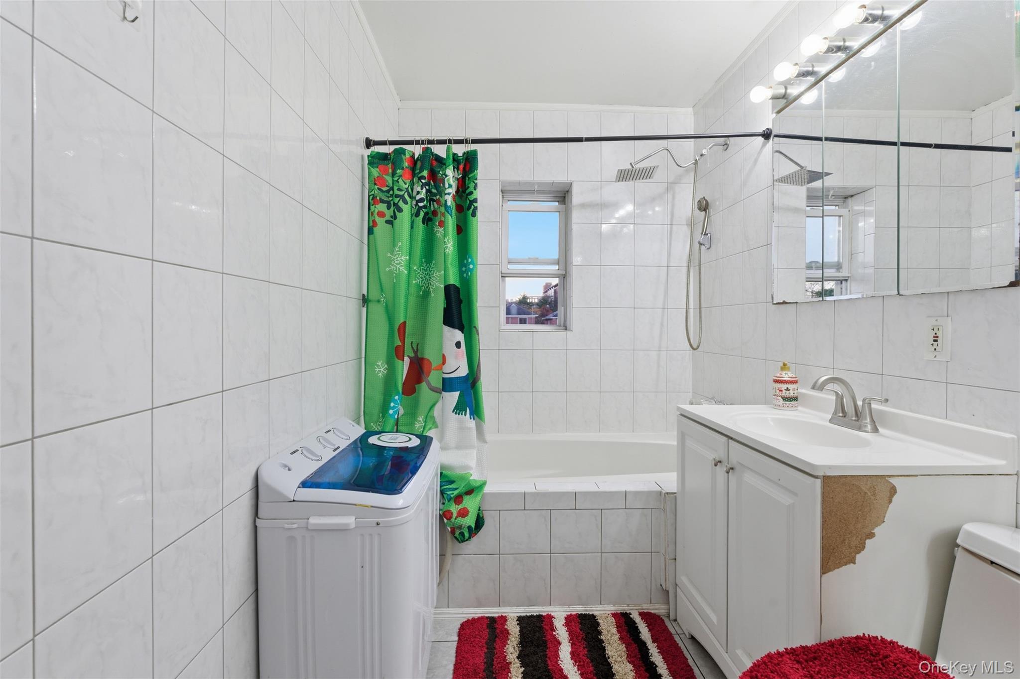 1408 Astor Avenue Bronx, NY 10469 - Photo 13 of 21 Full Bathroom featuring tile walls, vanity, and tiled shower / bath