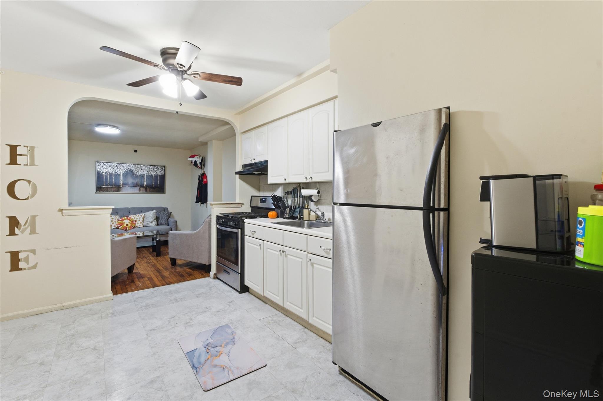 1408 Astor Avenue Bronx, NY 10469 - Photo 14 of 21 2nd floor Unit Kitchen featuring appliances with stainless steel finishes, white cabinets, arched walkways, light countertops, and ceiling fan