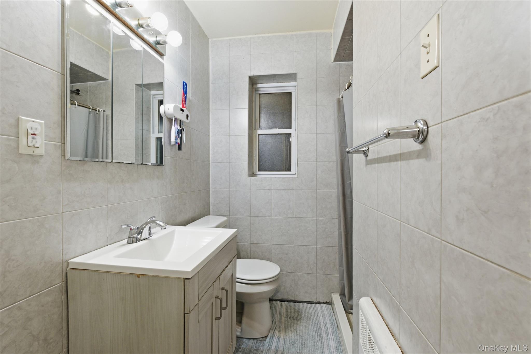 1408 Astor Avenue Bronx, NY 10469 - Photo 18 of 21 2nd Unit full Bathroom featuring tile walls, a shower stall, and vanity