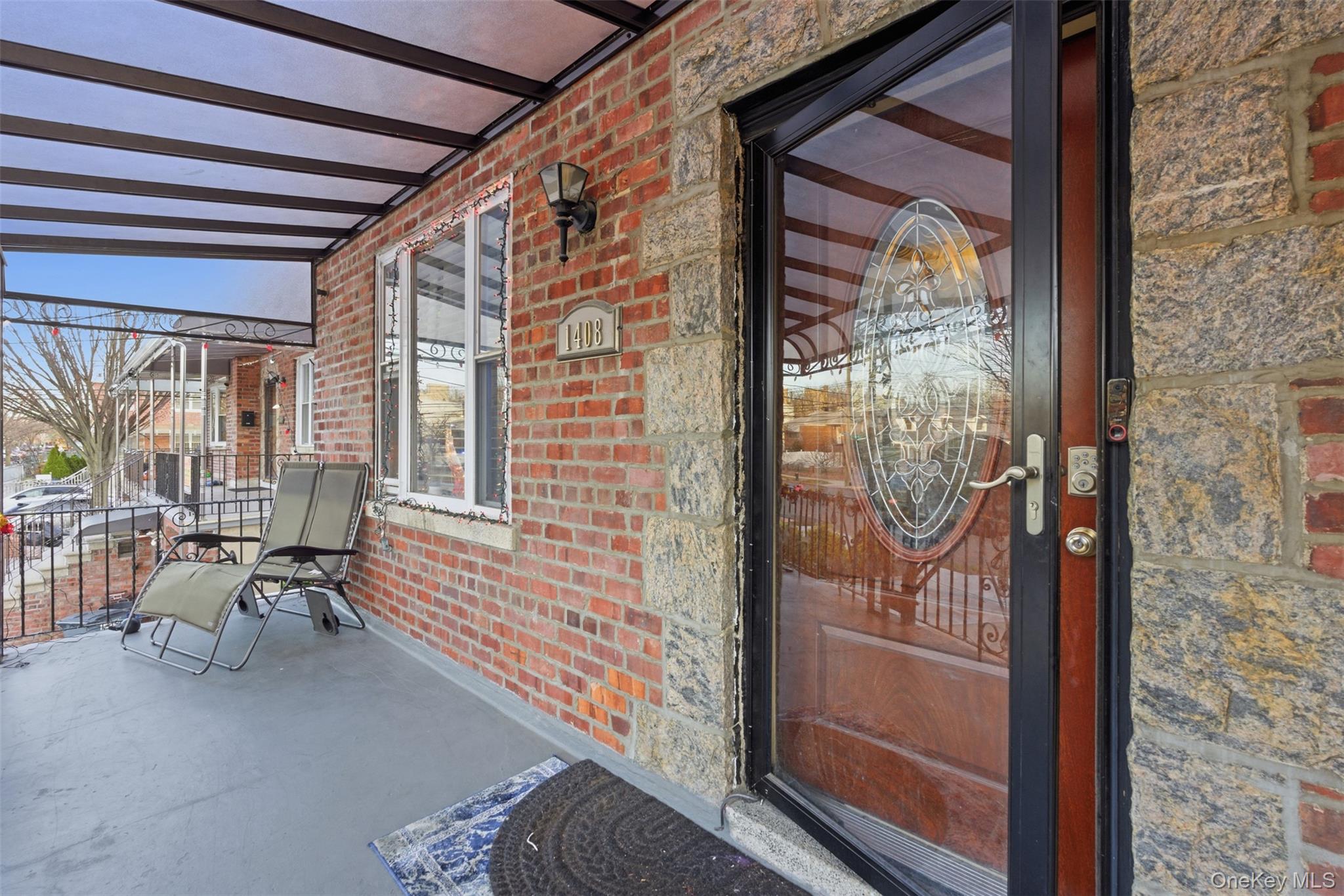 1408 Astor Avenue Bronx, NY 10469 - Photo 3 of 21 View of exterior entry with a porch and brick siding
