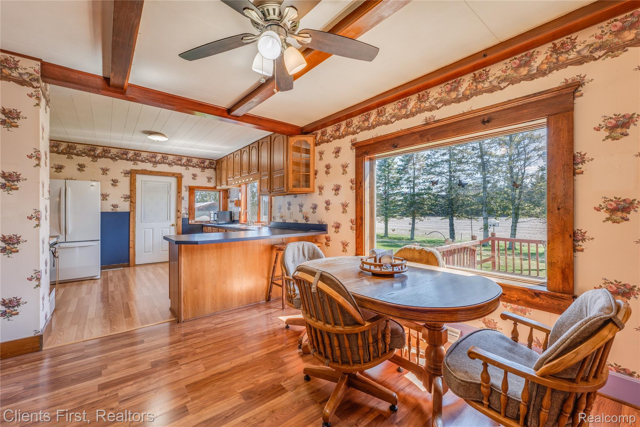 342 North Chambers Road Tawas City, MI 48763 - Photo 11 of 30 Dining space featuring beamed ceiling, wallpapered walls, light wood-style floors, and a ceiling fan