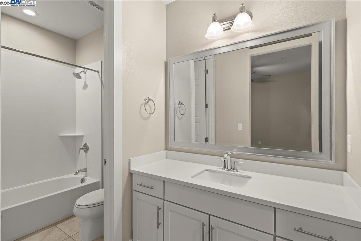 2969 Delamar Drive Dublin, CA 94568 - Photo 16 of 27 a bathroom with a sink a toilet and a large mirror