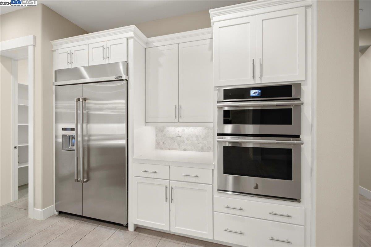 2969 Delamar Drive Dublin, CA 94568 - Photo 5 of 27 a kitchen with white cabinets and stainless steel appliances