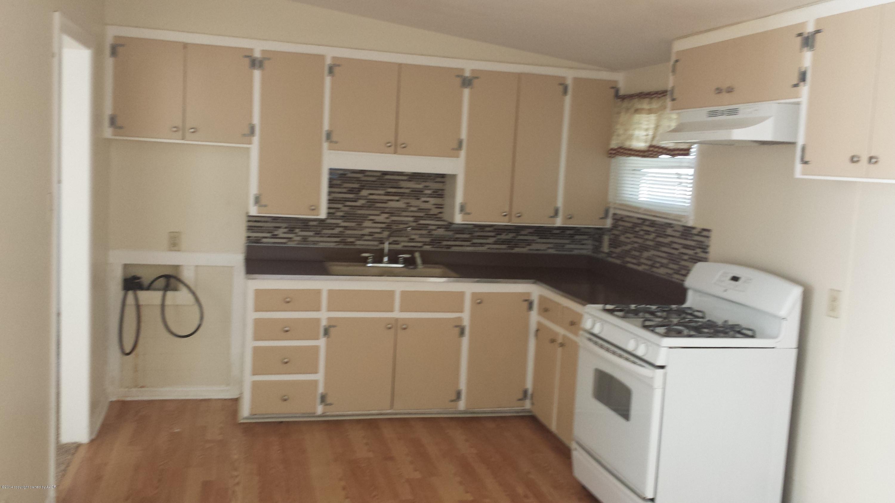 4420 South Hayden Street Amarillo, TX 79110 - Photo 4 of 16 a kitchen with white cabinets and white appliances