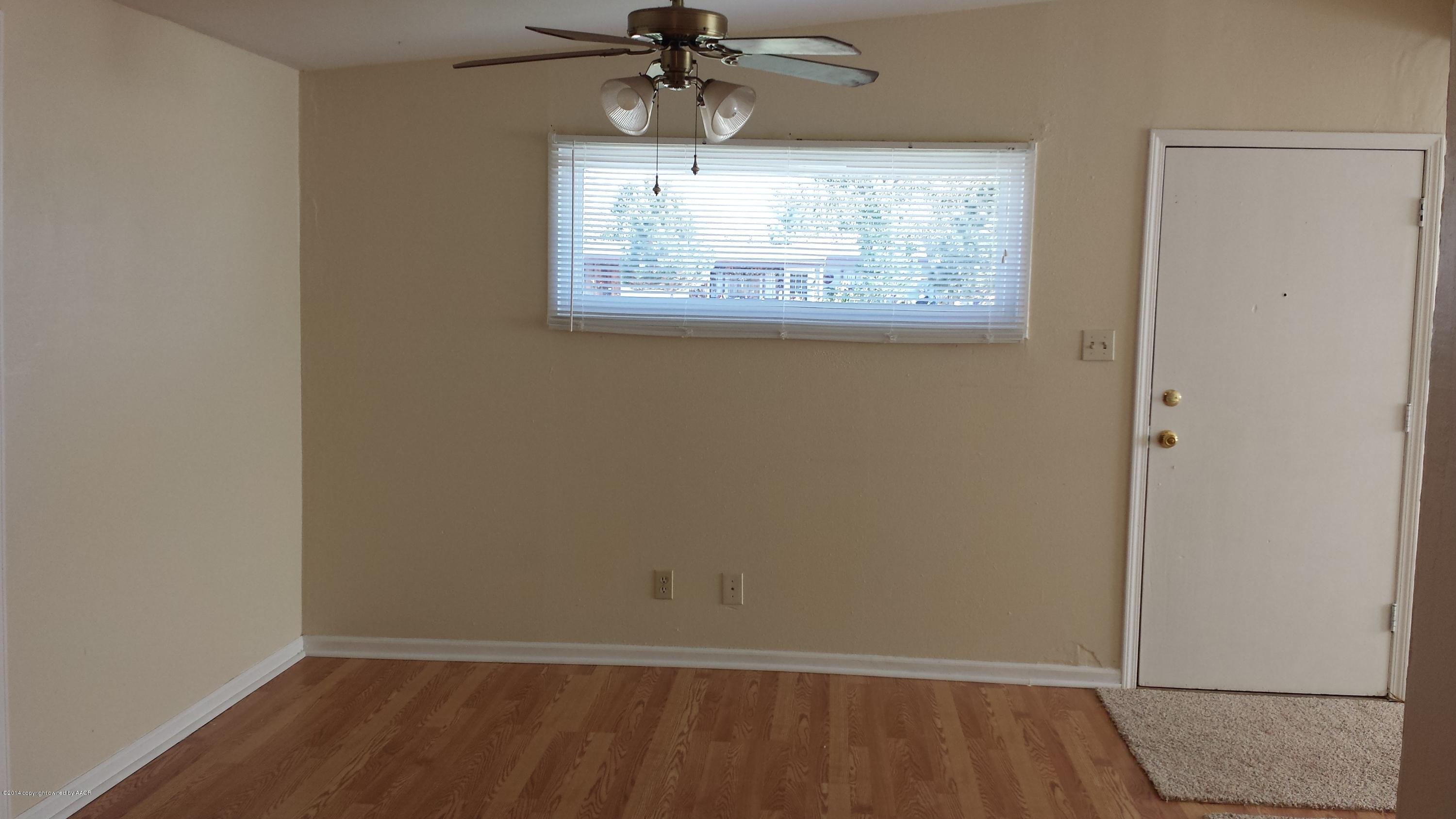 4420 South Hayden Street Amarillo, TX 79110 - Photo 7 of 16 an empty room with wooden floor fan and windows
