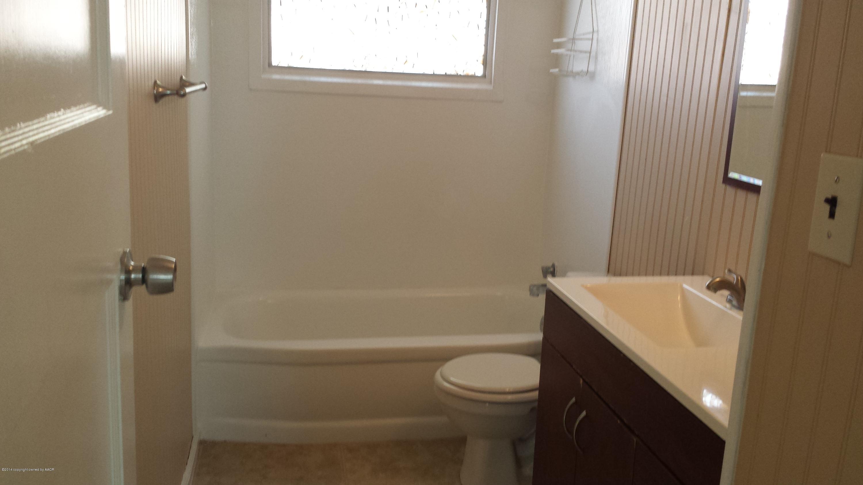 4420 South Hayden Street Amarillo, TX 79110 - Photo 9 of 16 a bathroom with a sink a toilet and shower