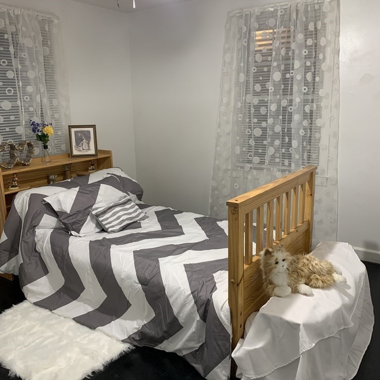 23 Notre Dame Street Springfield, MA 01104 - Photo 7 of 28 a bedroom with a bed and a chandelier