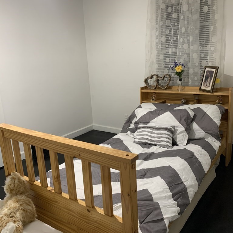 23 Notre Dame Street Springfield, MA 01104 - Photo 8 of 28 a bedroom with a bed and wooden floor