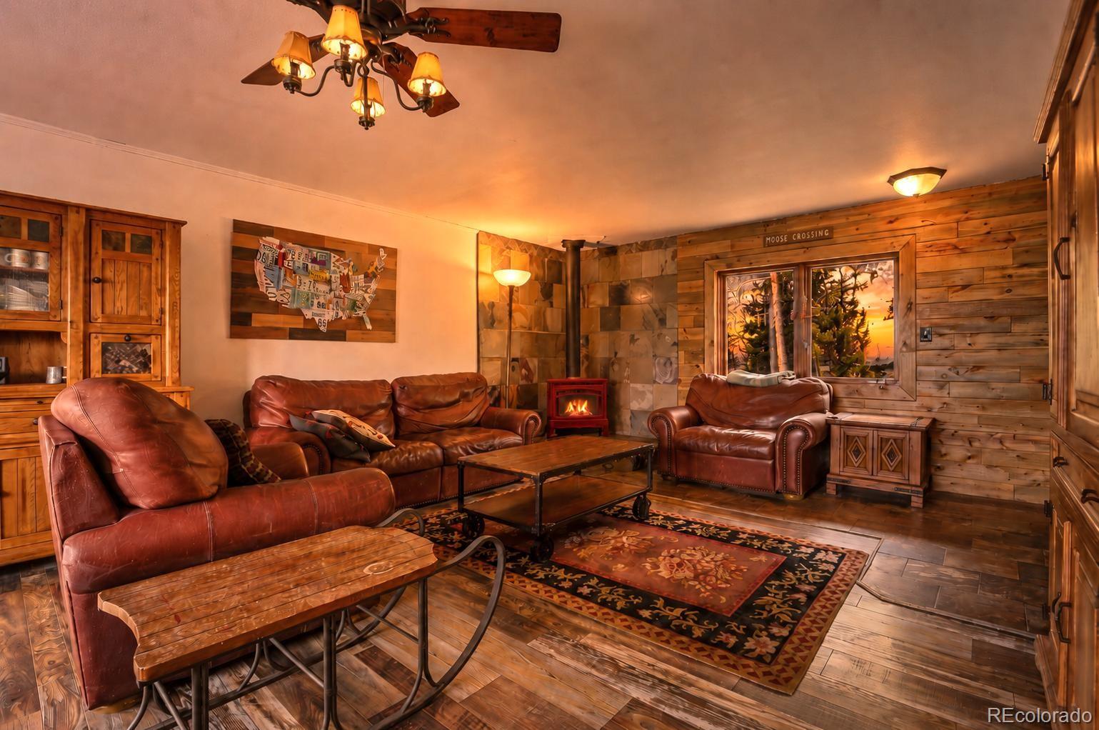 9225 Sandy Lane Conifer, CO 80433 - Photo 14 of 45 a living room with furniture a rug and a chandelier