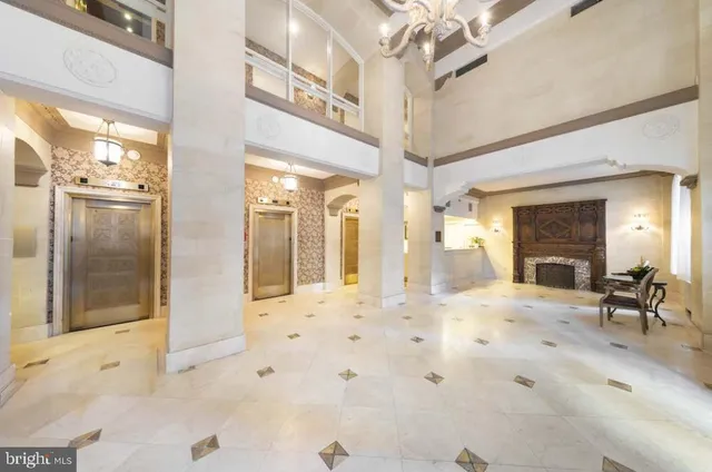 a view of a hallway with furniture and a chandelier