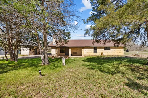 a front view of a house with a yard and trees