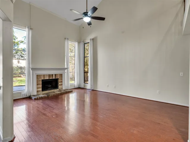 an empty room with windows a fireplace
