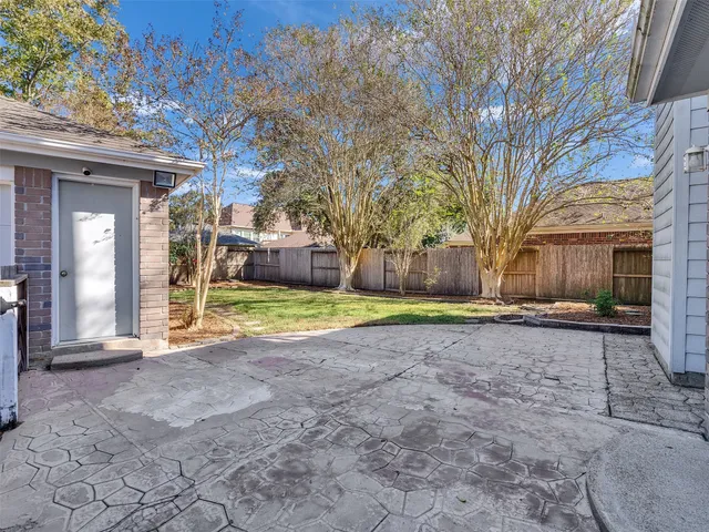 a view of a house with a big yard and large tree