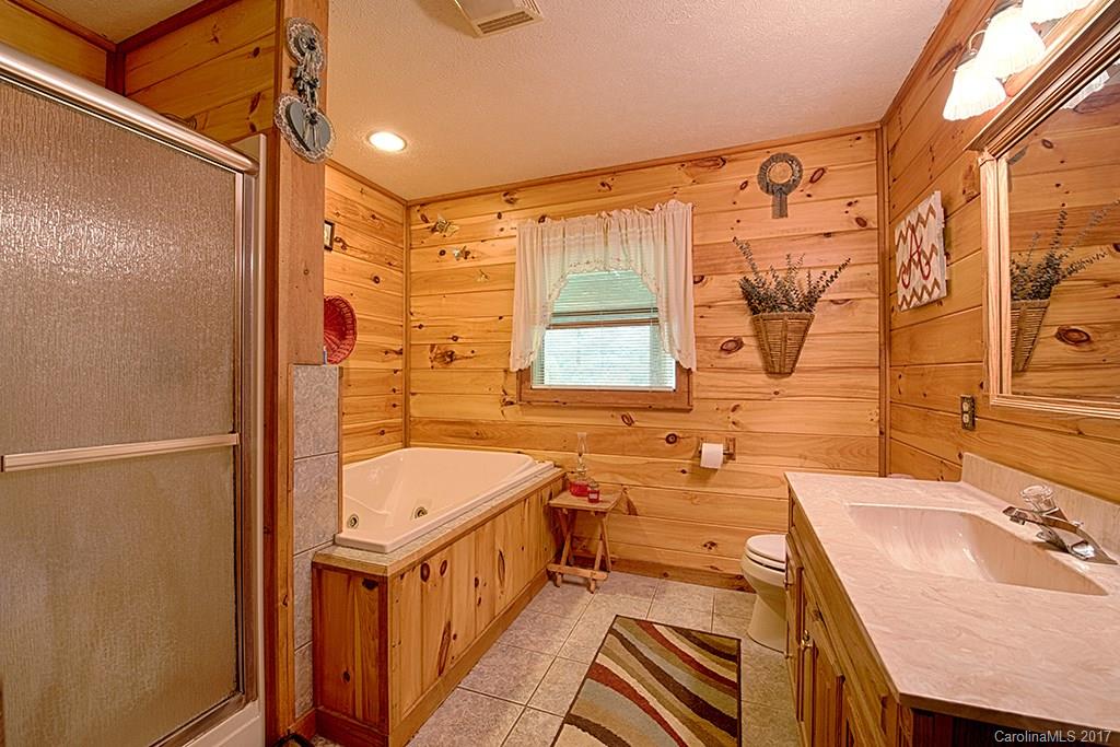 95 Straightup Road Maggie Valley, NC 28751 - Photo 11 of 24 a bathroom with a tub sink toilet and mirror