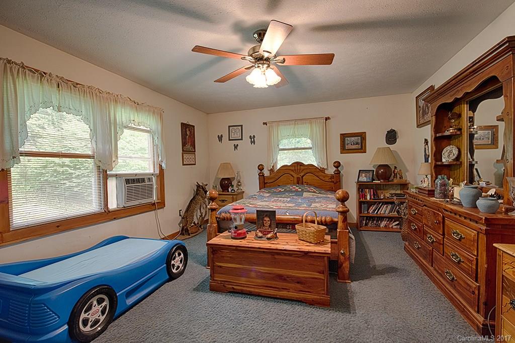 95 Straightup Road Maggie Valley, NC 28751 - Photo 9 of 24 a bedroom with a bed and a chandelier