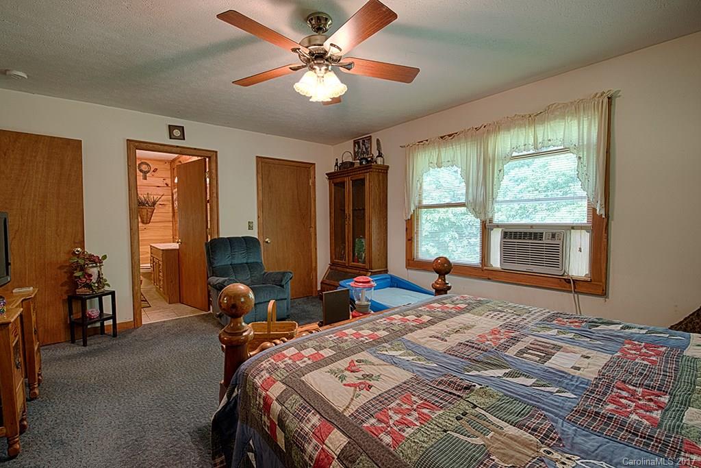 95 Straightup Road Maggie Valley, NC 28751 - Photo 10 of 24 a bedroom with a bed a large window with table and chairs