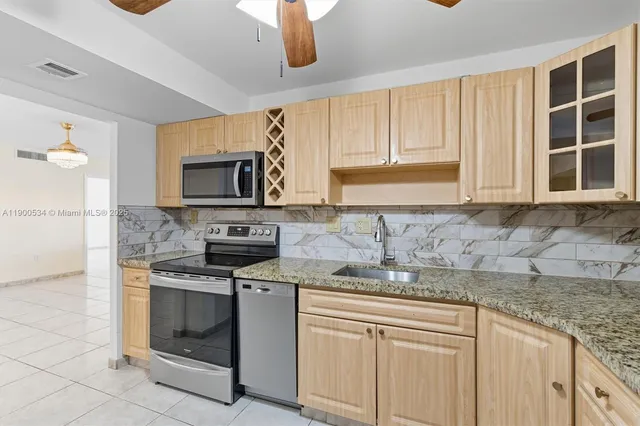 a kitchen with sink a microwave and cabinets