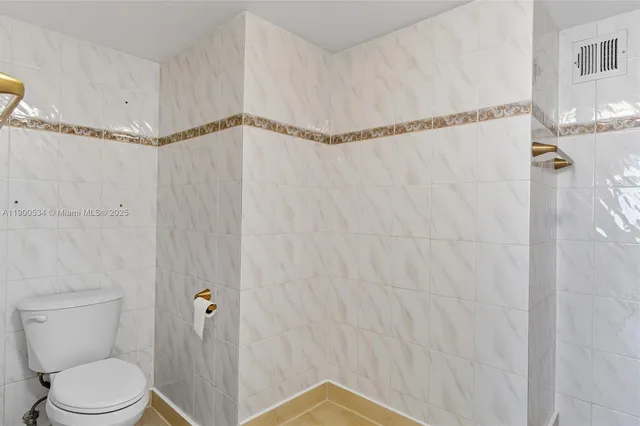 a bathroom with a shower a toilet and a shower