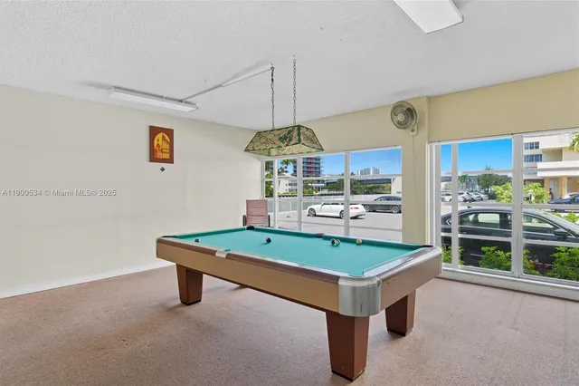 a room with pool table and windows